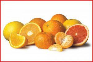 A pile of oranges and grapefruits on top of each other.