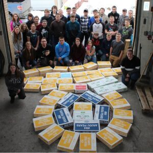 Group photo with numerous yellow packages arranged in a circle.